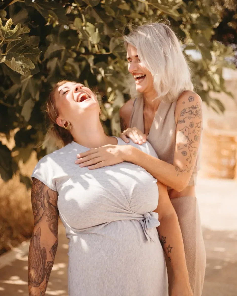 Zwei Frauen aus der SULIA Community lachen gemeinsam im Garten.